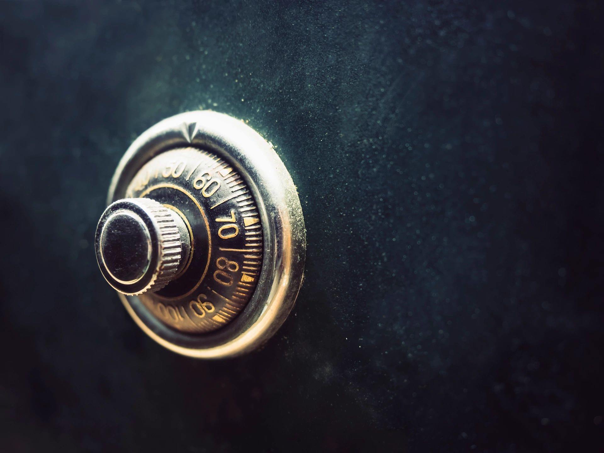 Brass combination lock on a near-black background — Lock City locksmith work